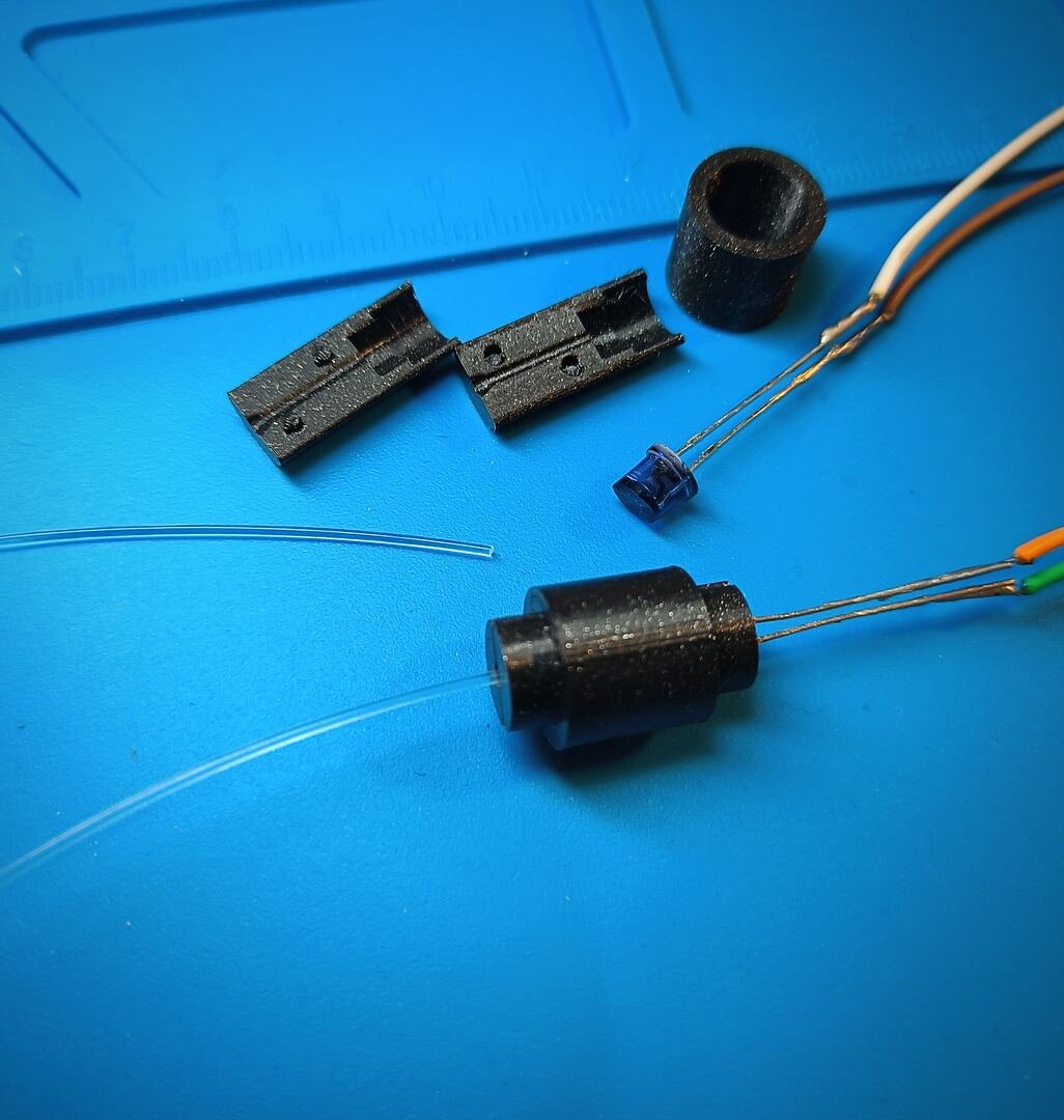 Phase 2 progress (May 2026): self-designed OpenSCAD 3D-printed optical fixture — split-clamshell housing aligning IR emitter LED, plastic optical fiber, and phototransistor with zero play for repeatable bend-sensor readings